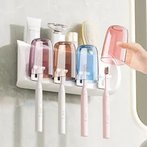 White wall-mounted toothbrush holder with four tinted cups, shown with brushes in a bathroom
