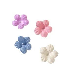 Four miniature five-petal fabric flower appliqués in purple, pink, blue and ivory on white