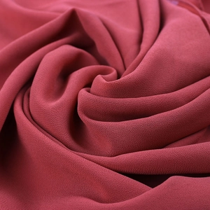 Detailed close-up of dark red pearl chiffon fabric showing soft draping and grainy texture