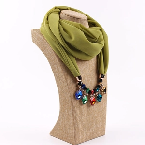 Close-up of green chiffon scarf necklace with large colorful faceted gemstones