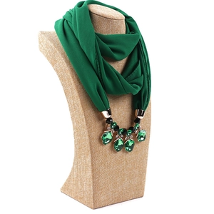 Detail of emerald chiffon scarf with gold rings and large green crystal pendants