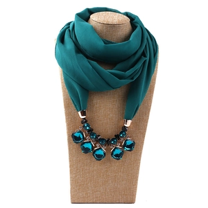 Detail of emerald green chiffon scarf necklace with rose gold hardware and jewel pendant