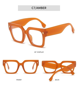 Detail view of square amber frames with golden metal accents and thick acetate texture