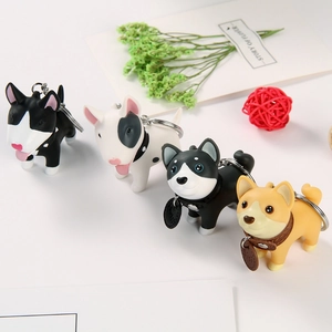 Vue détaillée de quatre porte-clés chiens en PVC coloré avec différentes poses mignonnes