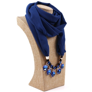 Detail of navy blue chiffon scarf featuring a luxury gemstone necklace pendant accessory
