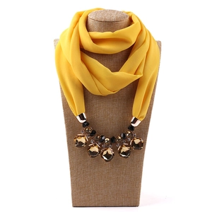 Macro shot of bright yellow chiffon scarf necklace with amber faceted resin beads