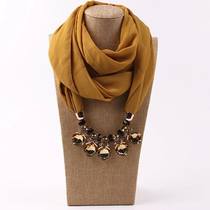 Detailed close-up of mustard yellow chiffon scarf necklace with amber crystal pendants