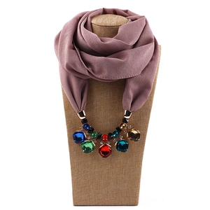 Detail of pink chiffon scarf necklace with colorful faceted gemstone charms on a bust