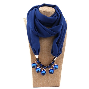 Detail of dark blue chiffon scarf necklace with large faceted blue gemstones and gold beads