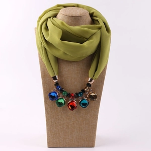 Detail of green chiffon scarf with colorful resin gemstone alloy pendant charms