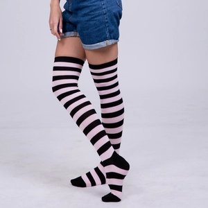 Close-up of pink and black striped over-the-knee socks paired with denim shorts