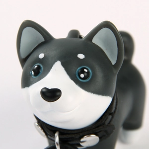 Close-up of cute black and white Shiba Inu keychain with rivet collar and blue eyes