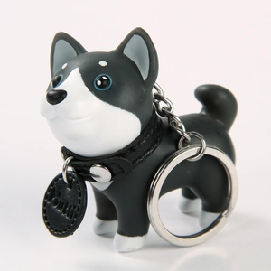 Detailed view of cute black and white dog keychain with silver ring and leather collar