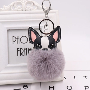 Detail of cute puppy faux leather charms and grey pompom with silver keyrings