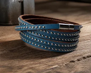 Detail of dark blue multi-layer woven leather bracelet with punk metal studs and magnetic clasp