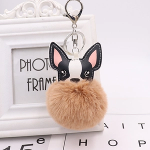 Close-up of a French Bulldog charm with a large brown pom-pom and metal keyring attachment