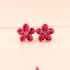 Elegant ruby flower stud earrings with rose gold plating and sparkling red gemstones
