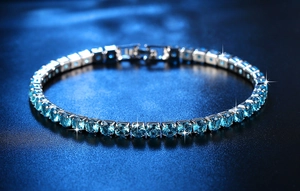 Nahaufnahme glänzender dunkelblauer Zirkoniasteine auf silbernem Tennisarmband