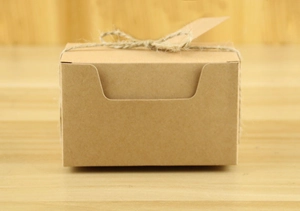 Close-up of 10cm kraft paper gift box with natural twine bow on wood background