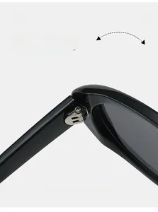 Detailed close-up of a durable silver metal hinge on retro oval black sunglasses