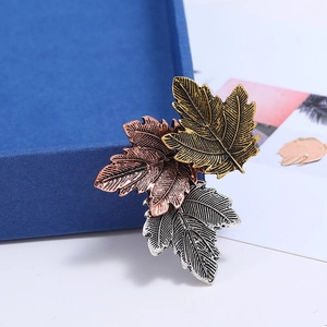 Detail of vintage maple leaf brooch with textured gold, rose gold and silver finish