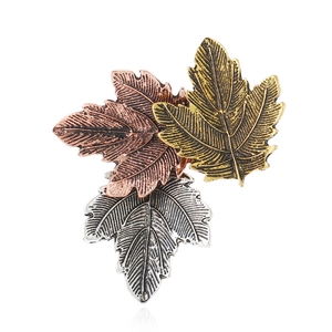 Detail of vintage maple leaf brooches in gold, copper and silver metallic tones