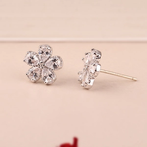 Macro view of S925 silver flower stud earrings with white zircons and hallmark