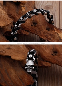 Macro detail of braided leather bracelet featuring intricately carved skull metal charms