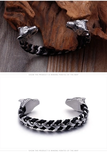 Detail of punk wolf head cuff bracelet with black braided leather and silver steel finish