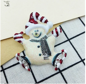 Macro detail of a colorful enamel Christmas snowman brooch with glitter and ice skates