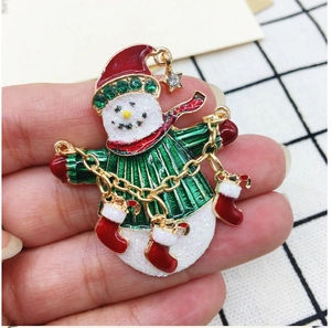 Detailed shot of snowman brooch with hanging Christmas socks and red sparkling hat
