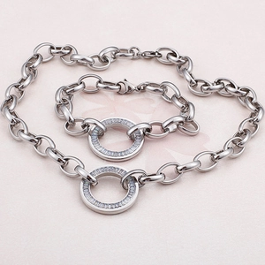 Silver chunky chain necklace and bracelet set with round zircon stones on pink background