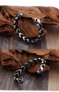 Detail of silver skull metal heads and black braided leather strap on punk bracelet