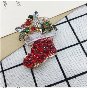 Detail of Christmas boot brooch with red rhinestones and gold-plated base decoration