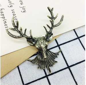 Close-up of vintage bronze reindeer brooch on retro letter paper with festive holiday patterns
