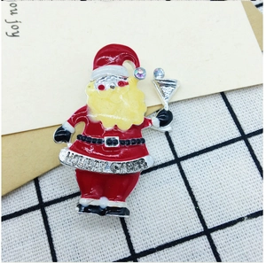 Macro detail of Santa Claus enamel brooch with sparkling rhinestones and Holiday Cheer engraving