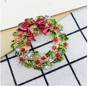 Detailed close-up of a Christmas wreath brooch with colorful enamel and sparkling rhinestones