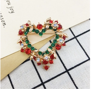 Detailed close-up of a heart-shaped wreath brooch with red and green rhinestones