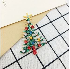 Close-up of a festive Christmas tree brooch with green enamel and colorful rhinestones