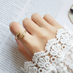 Close-up of a gold-plated adjustable embrace hand ring worn on the thumb in vintage style