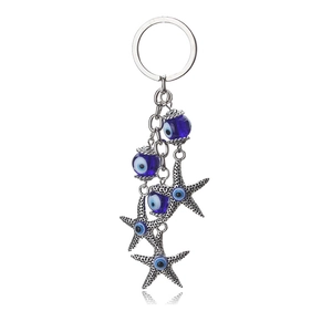 Lucky blue evil eye keychain with silver starfish pendants on white background