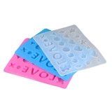 Vista macro di stampi in silicone con lettere LOVE e forme geometriche per resina fai-da-te