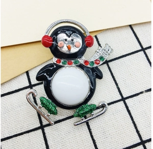 Detail of skating penguin brooch with colorful rhinestones on vintage envelope background