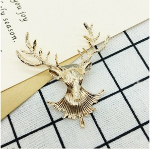 Detailed macro view of golden metal reindeer head brooch with intricate relief textures