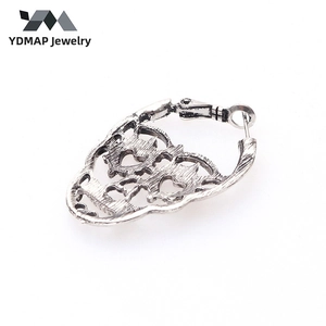Detail view of vintage skull earring with heart-shaped eyes and hollow metal design