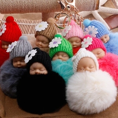 Close-up of sleeping baby doll plush keychains in various vibrant colors for bag decor