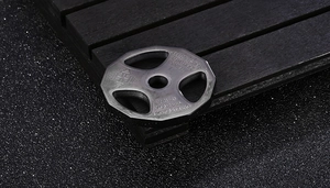 Macro shot of silver dumbbell pendant with motivational quote on black textured background