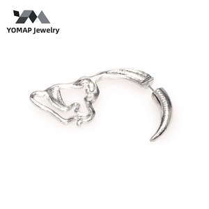 Macro shot of silver hollow dinosaur skull stud earring with glossy polished finish