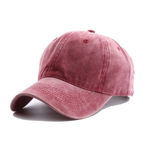Detailed texture of retro washed red cotton fabric on a vintage baseball cap surface