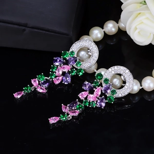Macro detail of silver drop earrings with pink, purple, and green AAA zircons on mirror